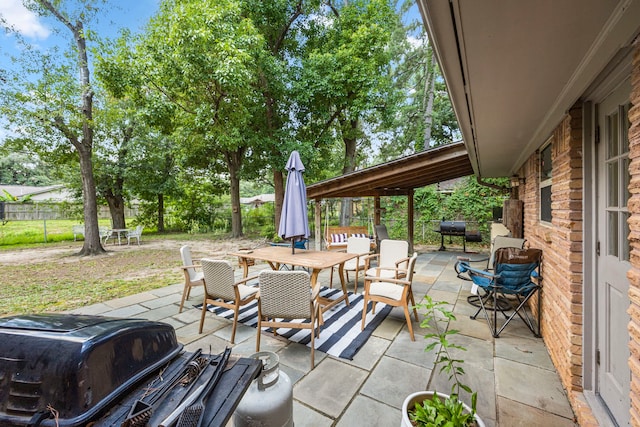 view of patio with outdoor dining area, grilling area, and a fenced backyard