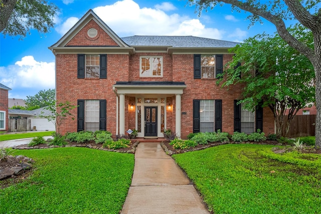1842 Lake Winds, Missouri City, TX 77459 - colonial house with roof with shingles, a front yard, and brick siding