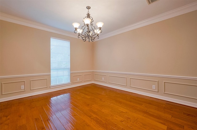 1842 Lake Winds, Missouri City, TX 77459 - spare room featuring a wainscoted wall, hardwood / wood-style flooring, a notable chandelier, and ornamental molding