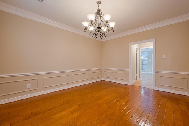 1842 Lake Winds, Missouri City, TX 77459 - empty room with a wainscoted wall, crown molding, a notable chandelier, and wood-type flooring