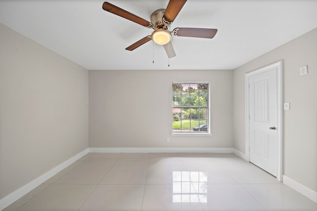 unfurnished room featuring ceiling fan, baseboards, and light tile patterned flooring