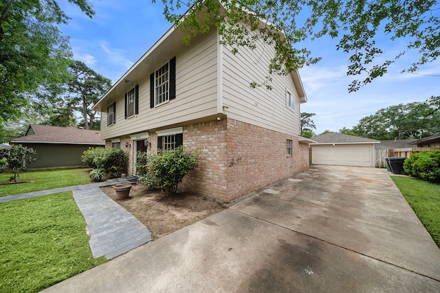 colonial house featuring an outdoor structure, a front lawn, brick siding, and a detached garage