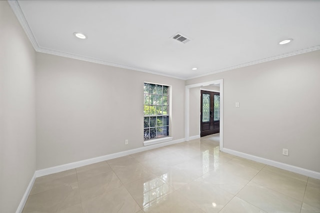 empty room featuring baseboards, crown molding, french doors, and visible vents