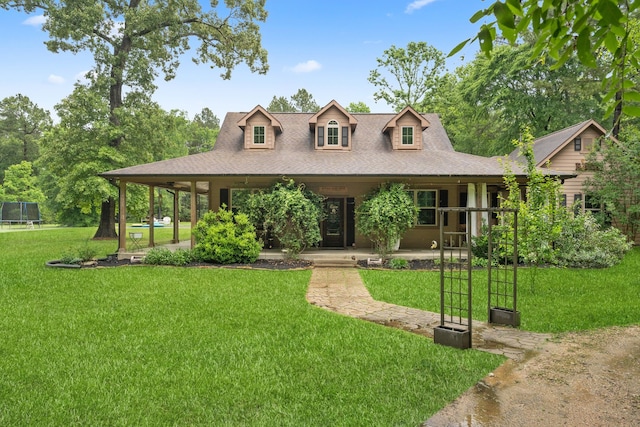 25672 Magnolia Pines Dr, Magnolia, TX 77355 - country-style home with a trampoline, covered porch, a front lawn, and a shingled roof