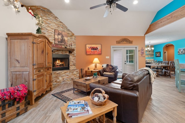 25672 Magnolia Pines Dr, Magnolia, TX 77355 - living room featuring ceiling fan, light wood-style flooring, a stone fireplace, high vaulted ceiling, and arched walkways