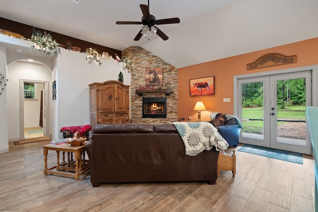 25672 Magnolia Pines Dr, Magnolia, TX 77355 - living room featuring a ceiling fan, arched walkways, vaulted ceiling, light wood finished floors, and a fireplace
