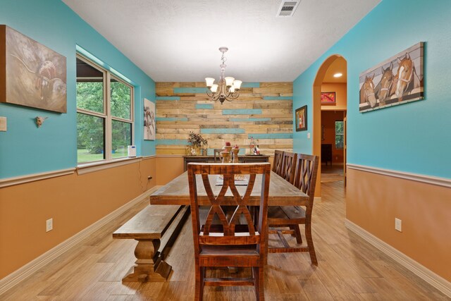 25672 Magnolia Pines Dr, Magnolia, TX 77355 - dining room with wood walls, a chandelier, wood finished floors, arched walkways, and baseboards