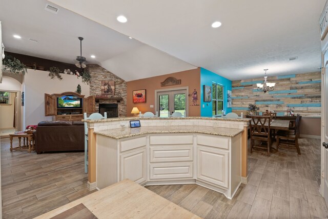 25672 Magnolia Pines Dr, Magnolia, TX 77355 - kitchen with open floor plan, a stone fireplace, light wood-type flooring, a chandelier, and recessed lighting