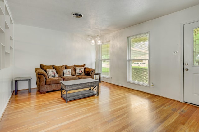 living room with a chandelier, visible vents, and light wood-style floors