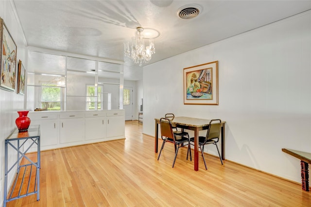 dining room with light wood-style floors, visible vents, and a notable chandelier