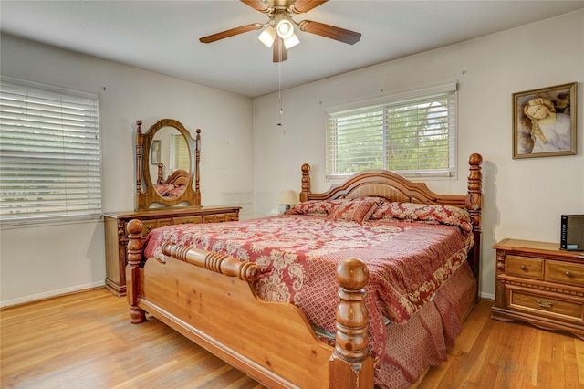 bedroom with light wood finished floors, baseboards, and ceiling fan