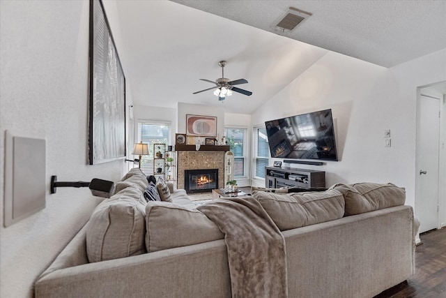 1201 Bering Dr Unit 28, Houston, TX 77057 - living room featuring a tile fireplace, dark wood-style floors, vaulted ceiling, visible vents, and ceiling fan
