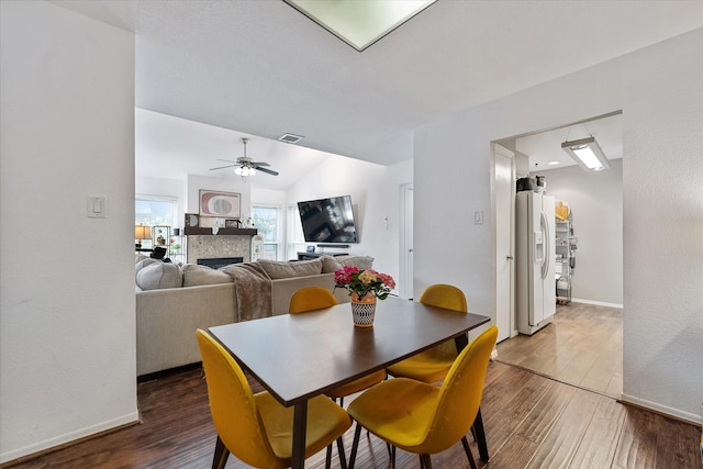 1201 Bering Dr Unit 28, Houston, TX 77057 - dining room featuring vaulted ceiling, wood finished floors, ceiling fan, a fireplace, and visible vents