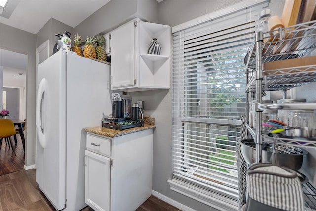 1201 Bering Dr Unit 28, Houston, TX 77057 - kitchen featuring open shelves, white cabinets, dark wood-style flooring, light stone countertops, and freestanding refrigerator