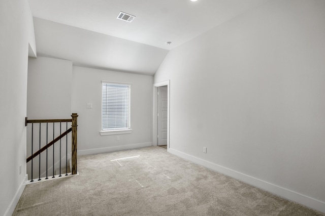 spare room featuring lofted ceiling, baseboards, and carpet flooring