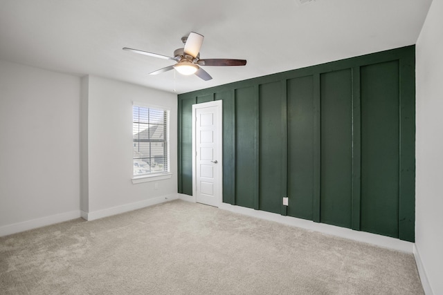 unfurnished bedroom with light colored carpet, baseboards, and ceiling fan