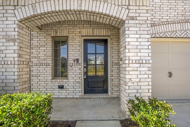 view of exterior entry with brick siding