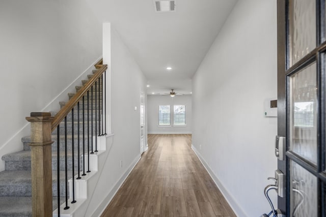hall with dark wood finished floors, stairs, baseboards, and recessed lighting