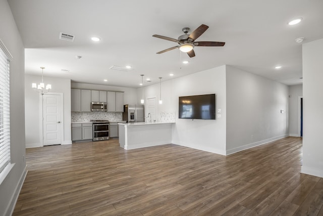 unfurnished living room with baseboards, ceiling fan, dark wood-style flooring, a sink, and recessed lighting