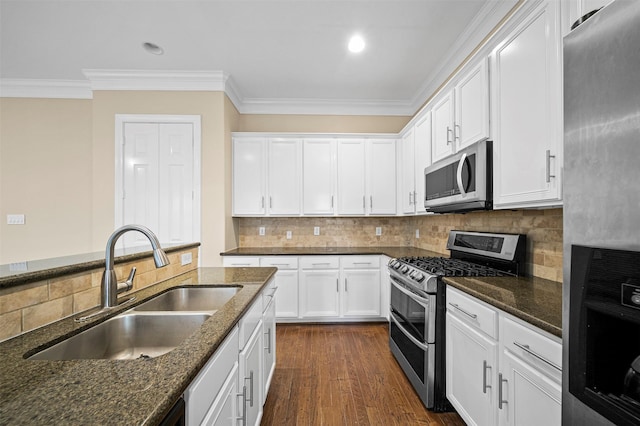 3444 Cline St, Houston, TX 77020 - kitchen with stainless steel appliances, a sink, crown molding, dark stone counters, and white cabinetry
