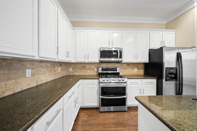 3444 Cline St, Houston, TX 77020 - kitchen featuring appliances with stainless steel finishes, dark stone countertops, and white cabinetry