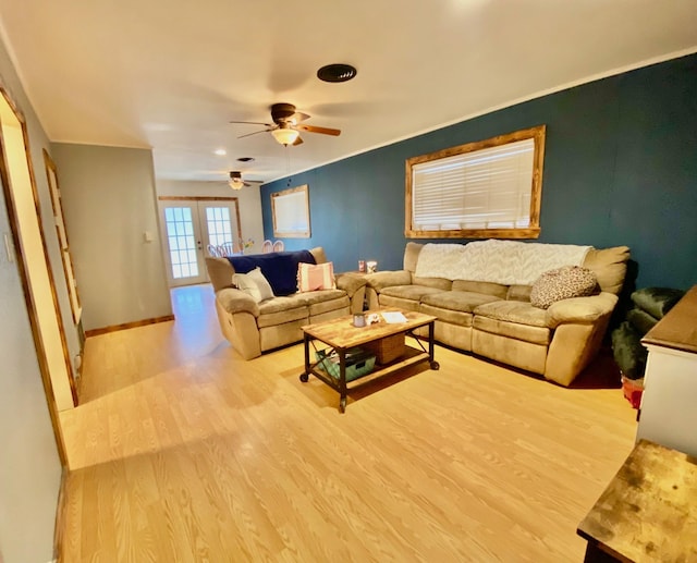 living room with ceiling fan, baseboards, and wood finished floors