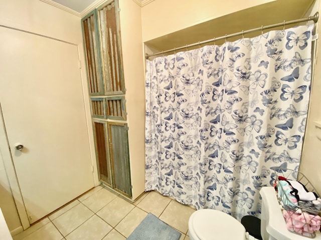 bathroom featuring tile patterned flooring, a shower with curtain, crown molding, and toilet