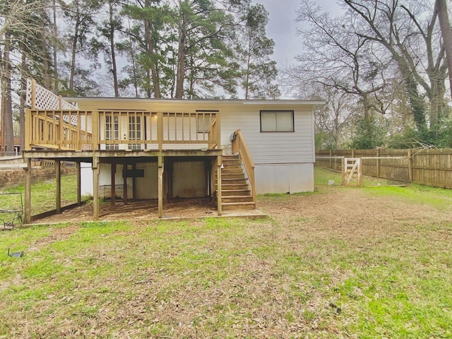rear view of house featuring a lawn, stairs, fence, and a deck