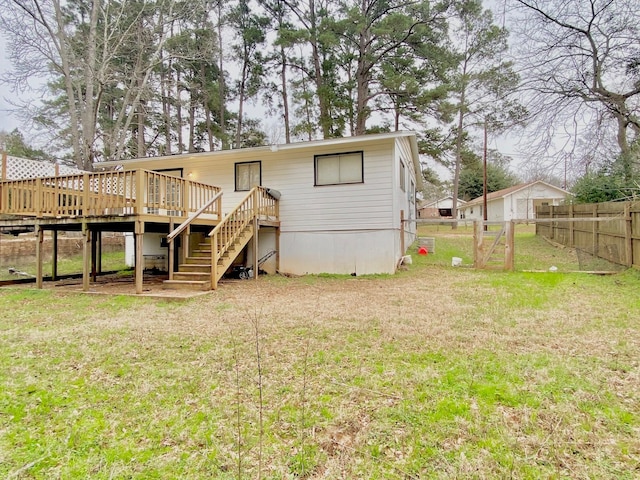 rear view of house with stairs, a yard, a fenced backyard, and a deck