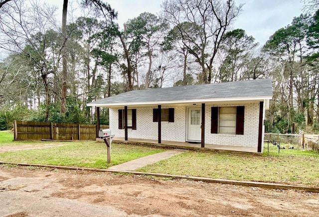 ranch-style home featuring brick siding, fence, a front yard, and covered porch