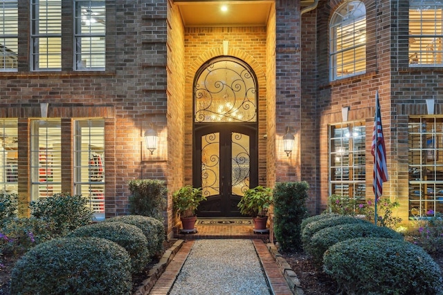 entrance to property featuring brick siding and french doors