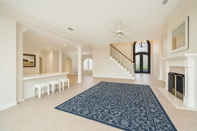 unfurnished living room with ornamental molding, visible vents, tile patterned flooring, and ceiling fan