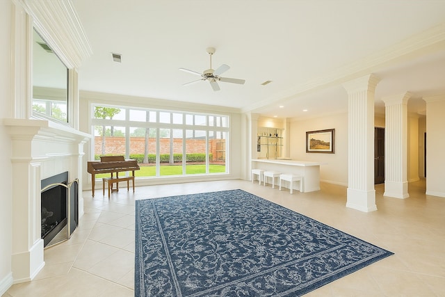 interior space featuring ornate columns, a ceiling fan, light tile patterned floors, and crown molding