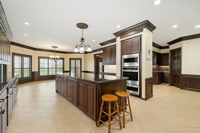kitchen featuring dark brown cabinets, stainless steel appliances, an inviting chandelier, and ornamental molding