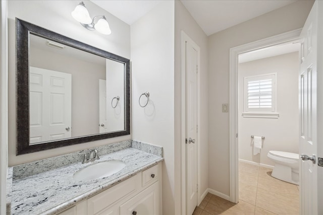 bathroom featuring baseboards, toilet, vanity, and tile patterned floors