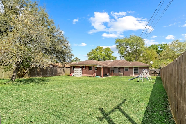 3721 Avalon Ave, Port Arthur, TX 77642 - rear view of house featuring a yard, a fenced backyard, and a playground