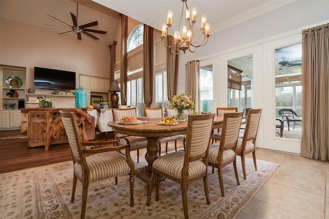 dining space with a wealth of natural light, ornamental molding, and ceiling fan with notable chandelier