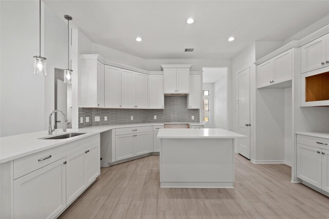 3220 Bello Green Ln, Katy, TX 77493 - kitchen featuring a sink, decorative backsplash, light wood finished floors, recessed lighting, and white cabinets
