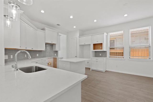 3220 Bello Green Ln, Katy, TX 77493 - kitchen with a sink, tasteful backsplash, recessed lighting, light wood-type flooring, and white cabinets