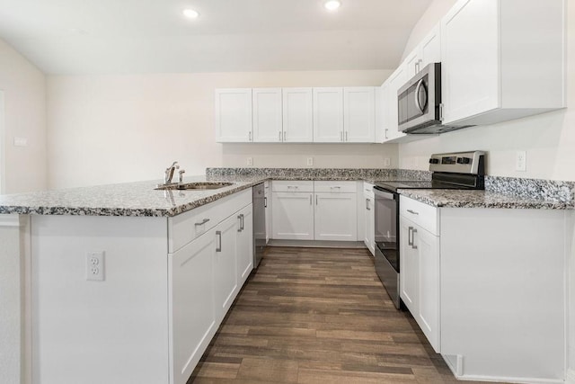 kitchen with stainless steel appliances, a peninsula, a sink, and white cabinetry