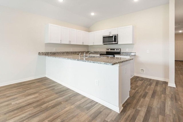 kitchen with stainless steel appliances, a peninsula, wood finished floors, and white cabinetry