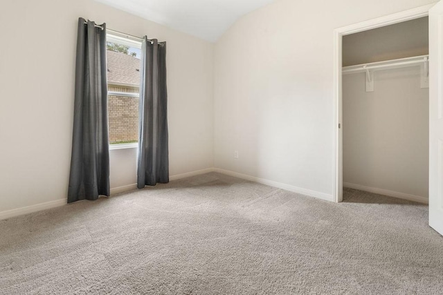 unfurnished bedroom with vaulted ceiling, baseboards, and carpet