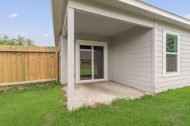 exterior space with a lawn, a patio, and fence