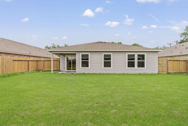 rear view of property featuring a fenced backyard and a yard