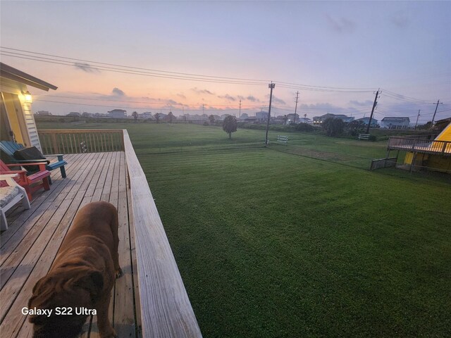 4215 San Jacinto Dr, Galveston, TX 77554 - yard at dusk with a lawn and a wooden deck
