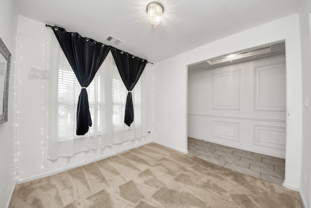 carpeted empty room with baseboards and visible vents