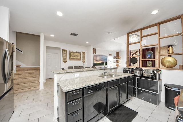 kitchen with a sink, visible vents, freestanding refrigerator, black dishwasher, and dark cabinetry
