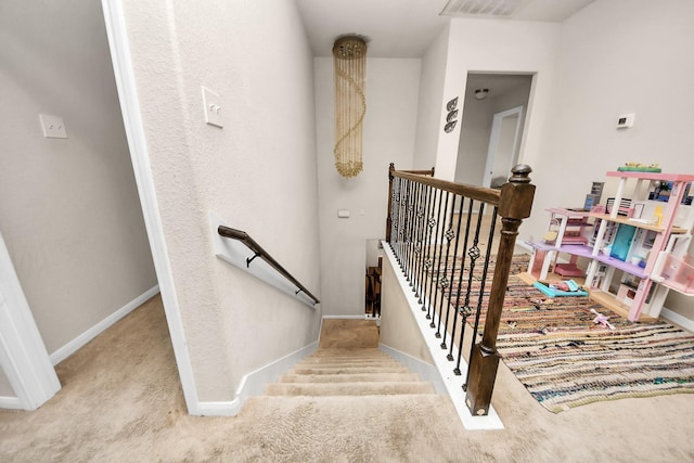 stairway featuring visible vents, carpet flooring, and baseboards