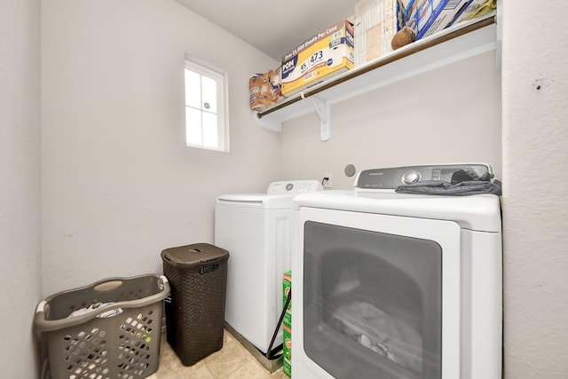 washroom featuring separate washer and dryer, laundry area, and light tile patterned floors