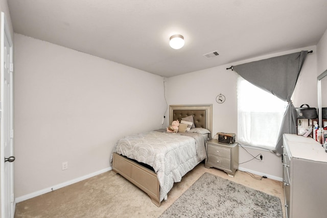 bedroom with baseboards, visible vents, and light colored carpet